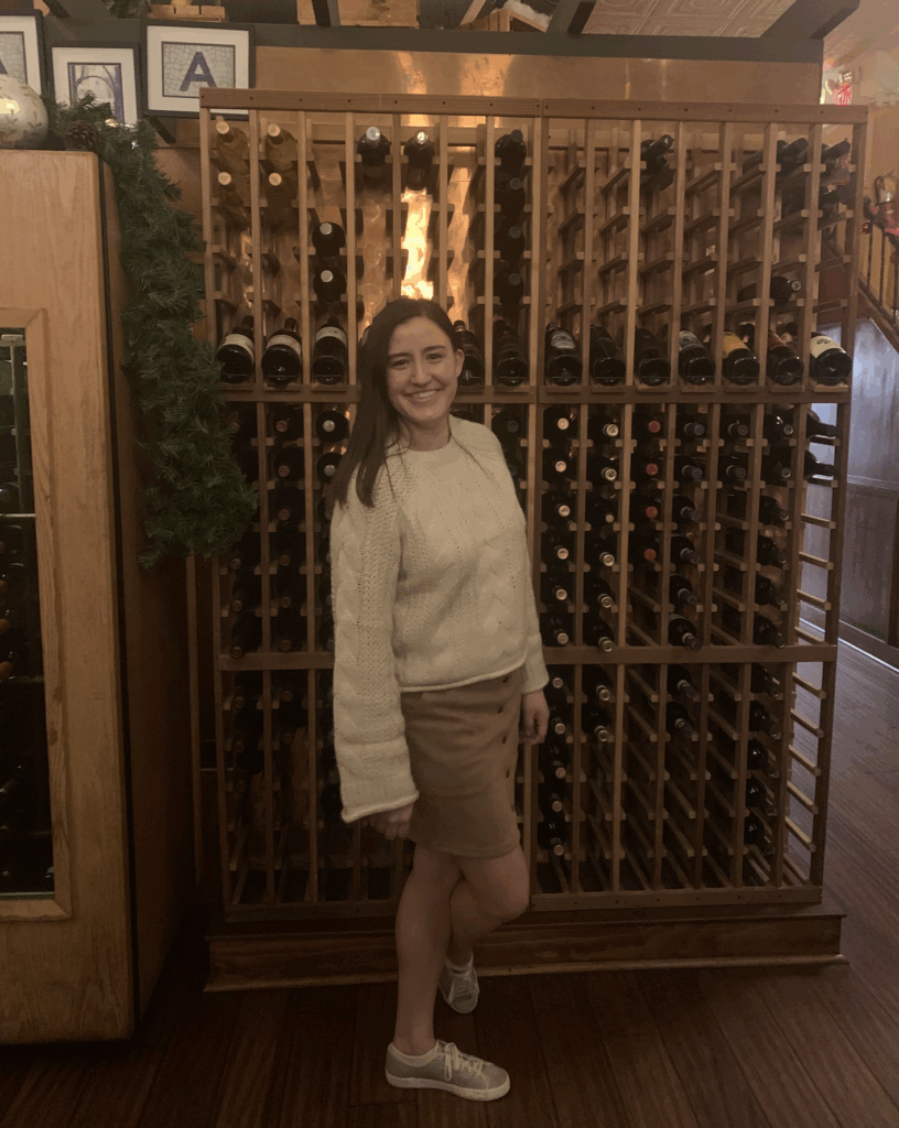 Alexa in front of wine rack at Strada Asheville
