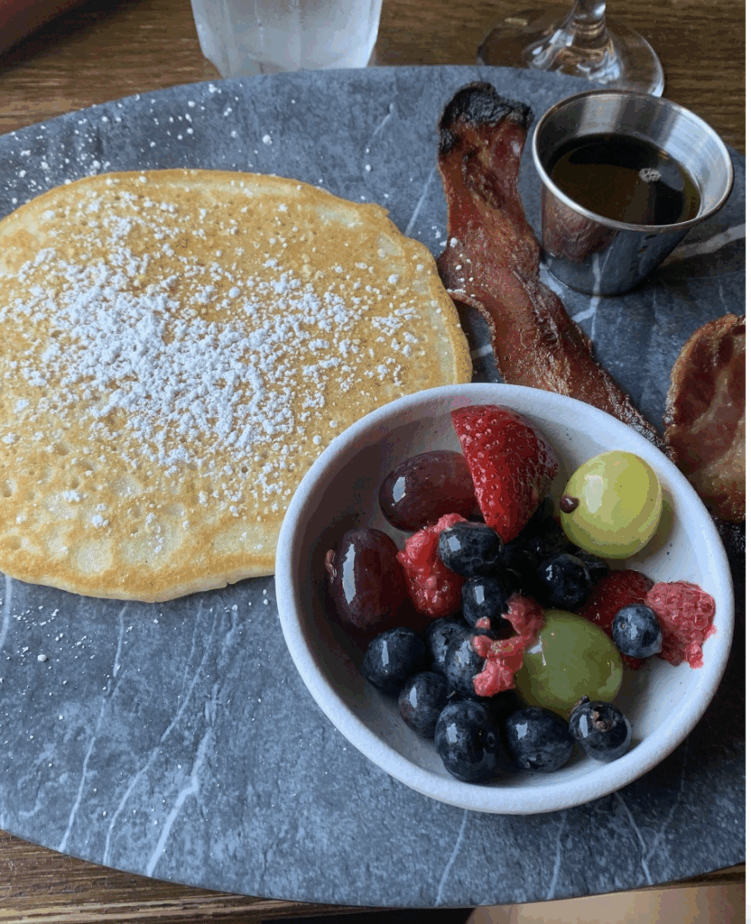 Brunch at Strada with gluten-free pancake, fruit cup, and crispy bacon